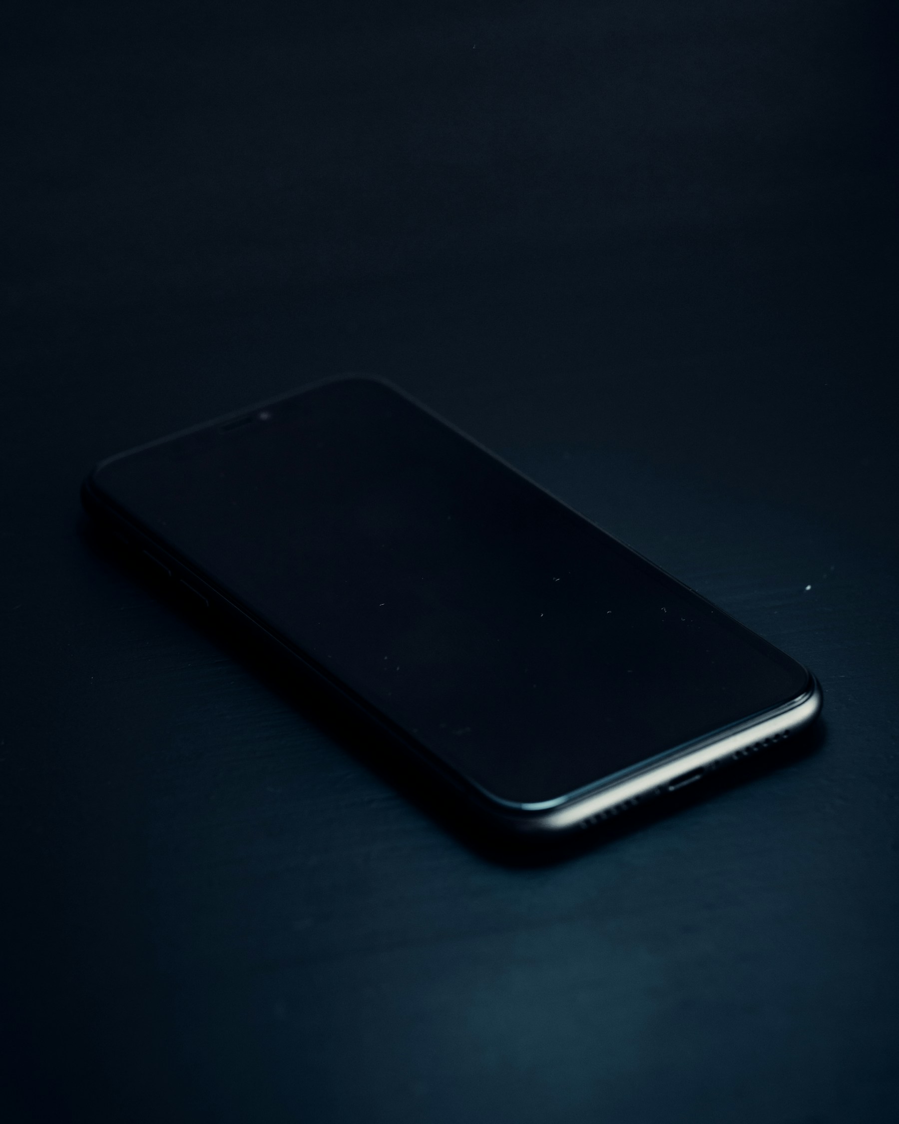 Close-up photograph of a smartphone on a dark work surface